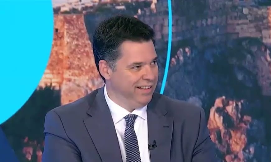 Ο Υφυπουργός Θανάσης Κοντογεώργης χαμογελά φορώντας κοστούμι και …