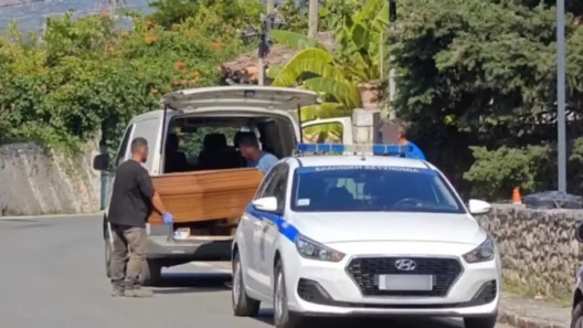 Αστυνομικό όχημα και άνδρες φορτώνουν φέρετρο σε βαν στον Μυστρά.