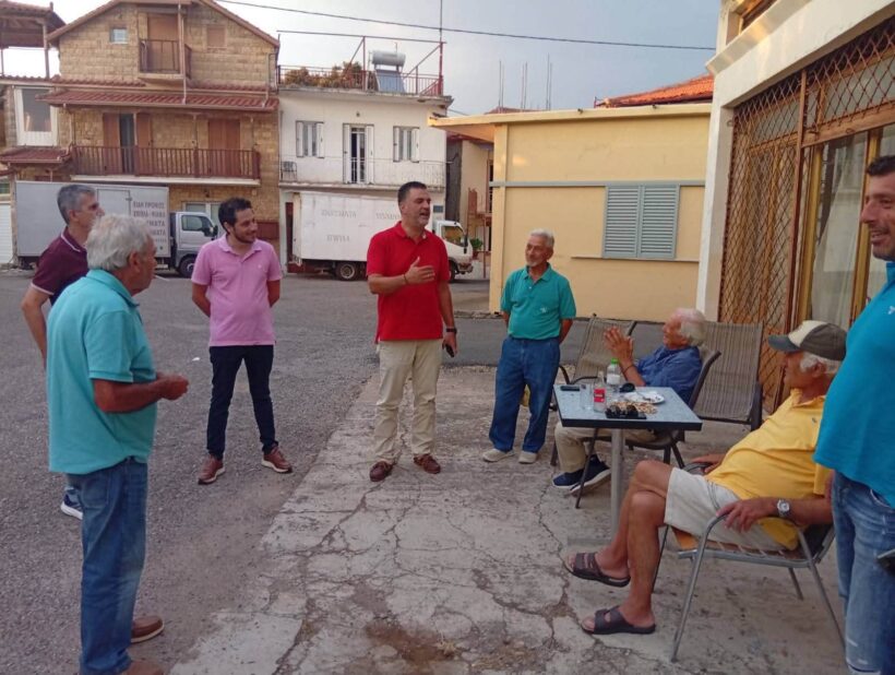 Ο Σπ. Σκιαδαρέσης, με κόκκινο μπλουζάκι, συνομιλεί με κατοίκους της…