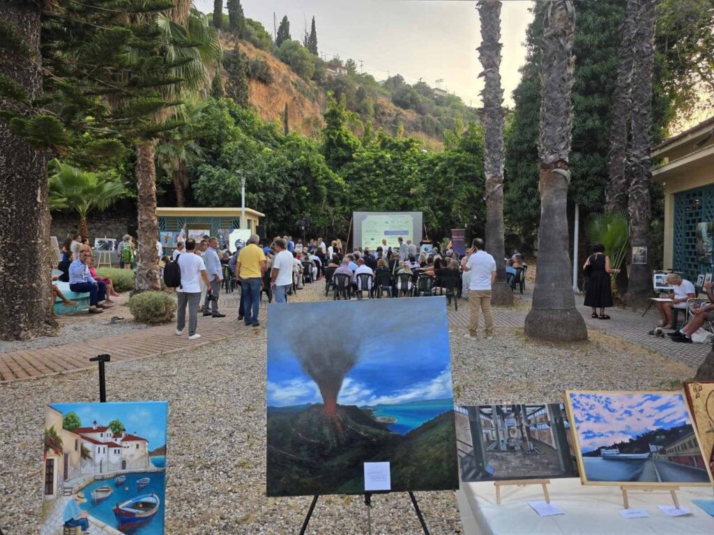 Εξωτερική έκθεση ζωγραφικής με κοινό, φοίνικες και οθόνη προβολής …