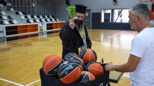 Ιερέας πραγματοποιεί αγιασμό, ραντίζοντας μπάλες μπάσκετ σε γήπεδ…