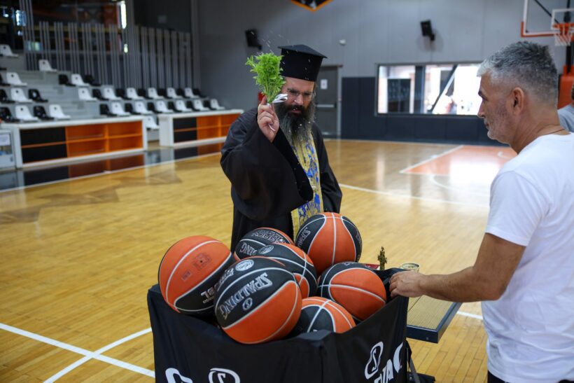 Ιερέας πραγματοποιεί αγιασμό, ραντίζοντας μπάλες μπάσκετ σε γήπεδ…