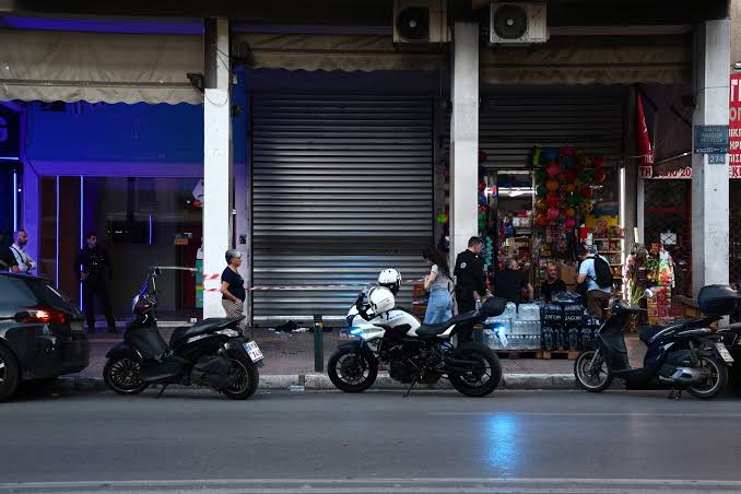 Αστυνομικοί και μοτοσικλέτες σε τόπο εγκλήματος με ταινία μπροστά…