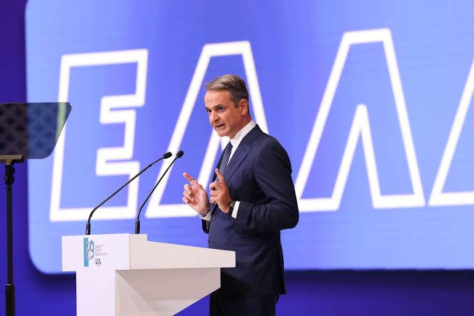 Ο Κυριάκος Μητσοτάκης μιλάει από βήμα, με φόντο το λογότυπο ΕΛΛΑ.