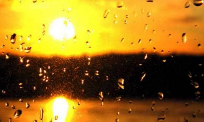 Σταγόνες βροχής σε παράθυρο με φόντο τον ήλιο που δύει ή ανατέλλει,…