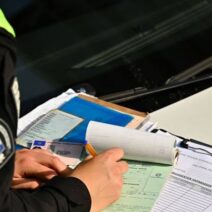 Αστυνομικός της Τροχαίας γράφει κλήση για παράβαση.
