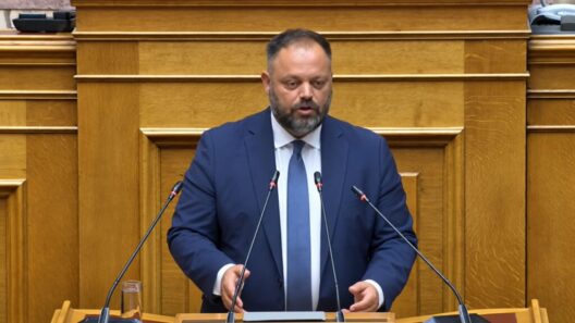 Γενειοφόρος πολιτικός με μπλε κοστούμι και γραβάτα μιλάει σε βήμα …