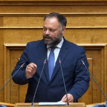 «Φτάνει με τις ευχές πάνω από τις στάχτες» 3 Βουλευτής μιλάει στο βήμα της Βουλής, φορώντας σκούρο κοστούμι και…