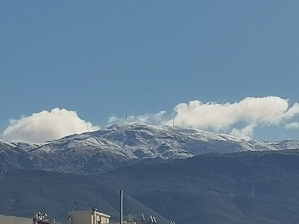 Παναχαϊκό: Τα Πρώτα Χιόνια της Χρονιάς στις Κορυφογραμμές με τις Ανεμογεννήτριες